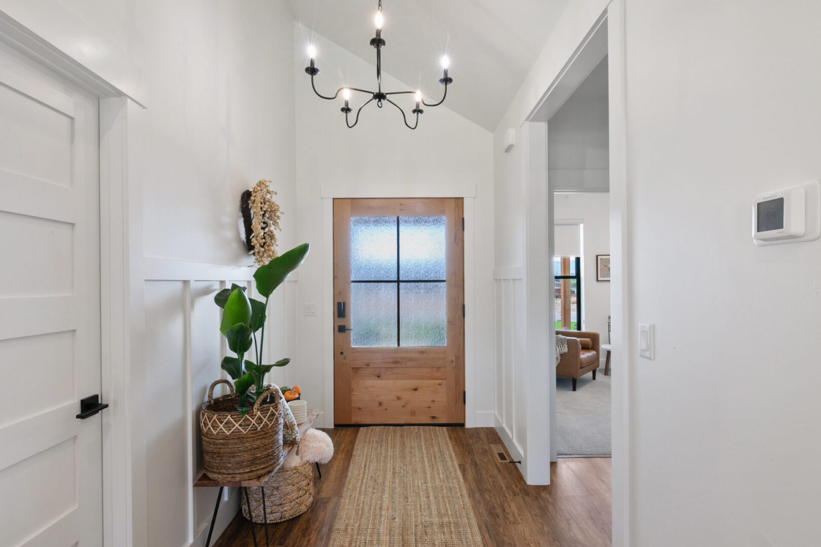 Bright entryway with wooden door and chandelier.