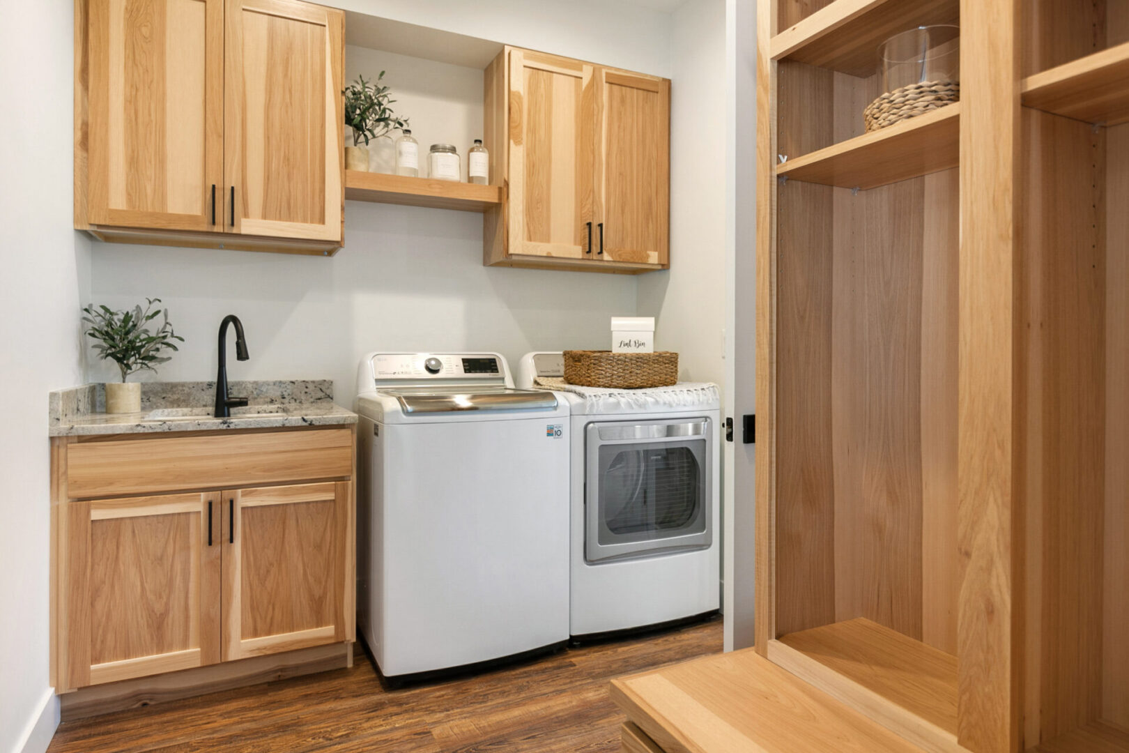 Laundry room with wooden cabinets and appliances.