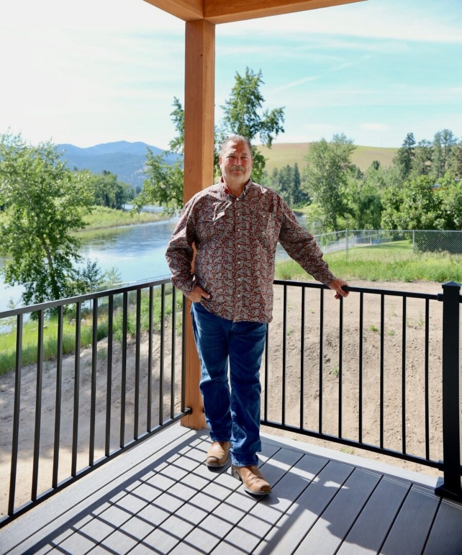 Man standing on a porch with scenic view.